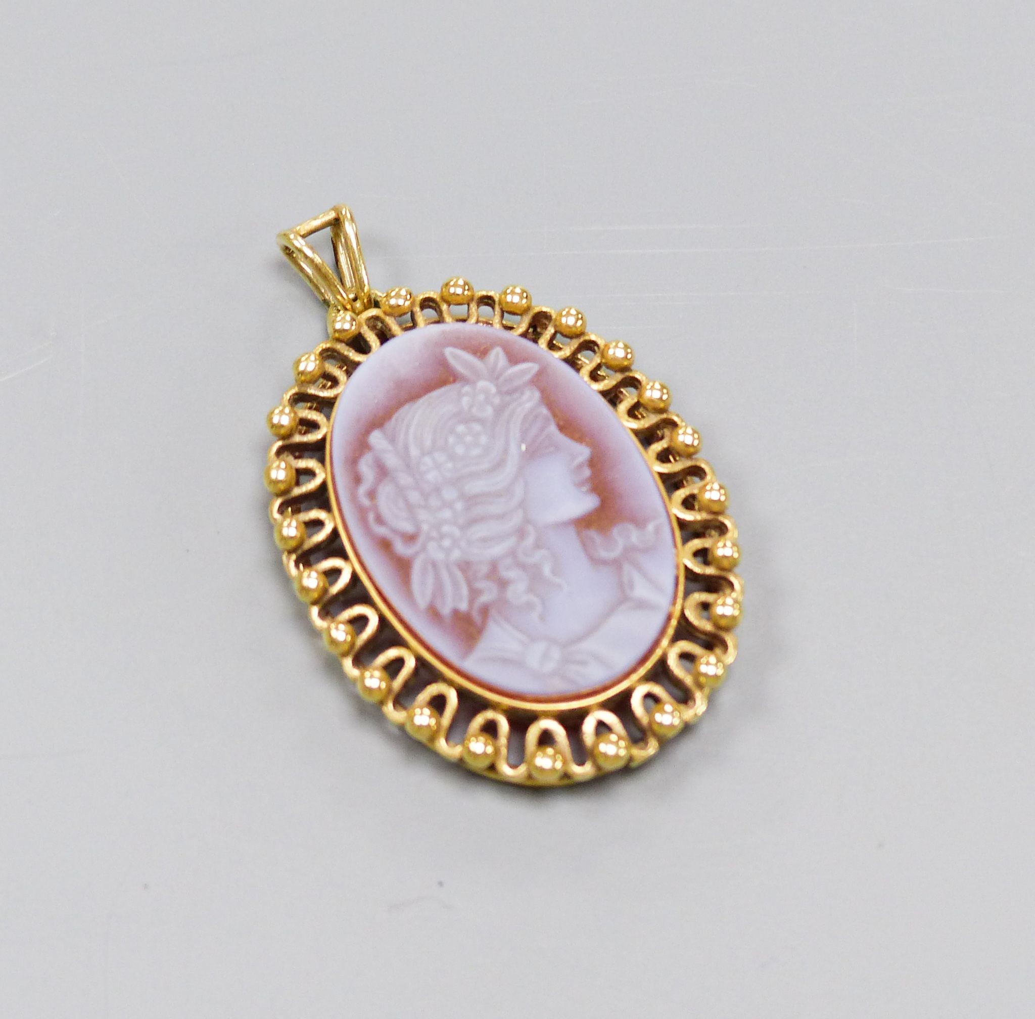 A 20th century pierced yellow metal mounted sardonyx oval pendant, carved with the bust of a lady to sinister, 32mm, gross 8.4 grams.